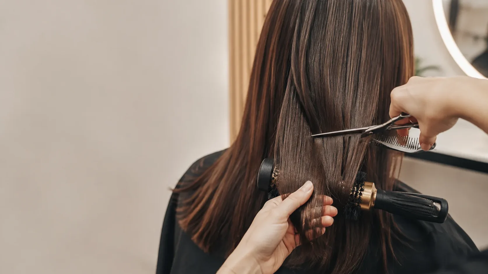 Corte e brushing em detalhe, centrado nas mãos e no cabelo